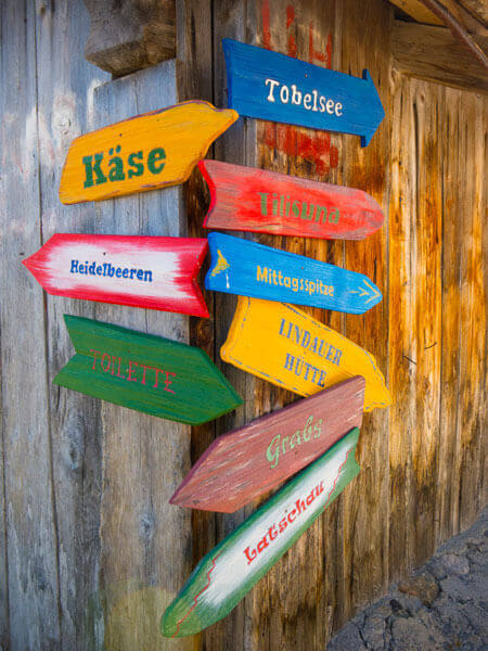 Bunte Wegweiser mit verschiedenen Angaben für Wanderer