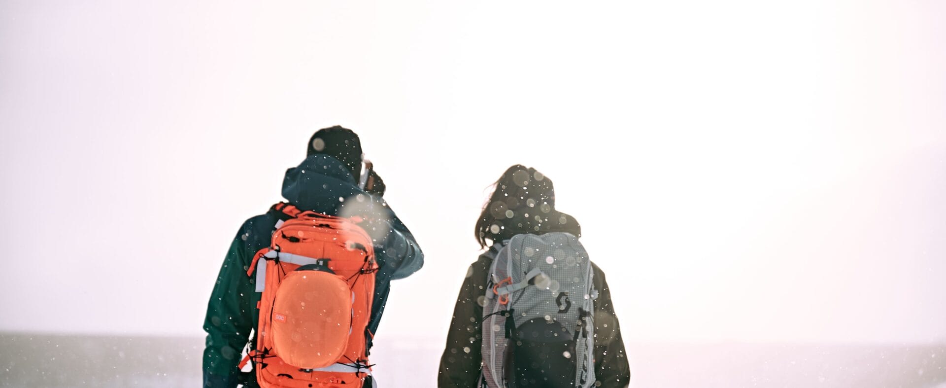 Mann und Frau schauen auf verschneite Landschaft