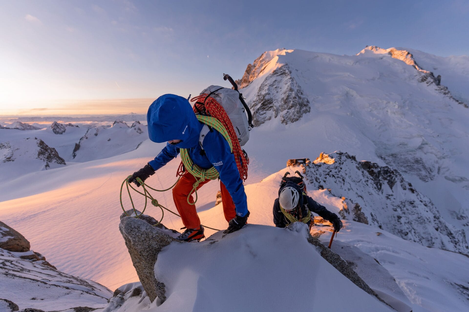 Bergsteiger im Sonnenuntergang auf einem verschneiten Bergkamm