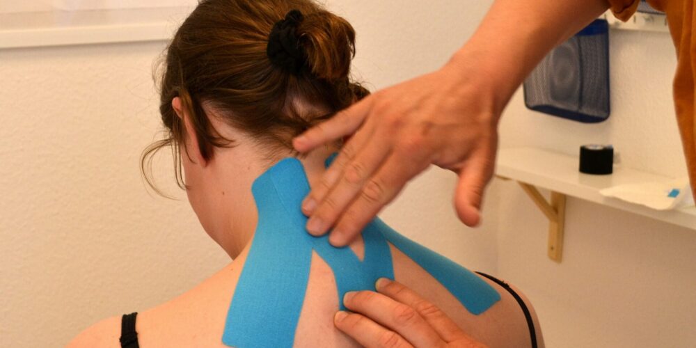 Der Nacken einer Frau wird getapet